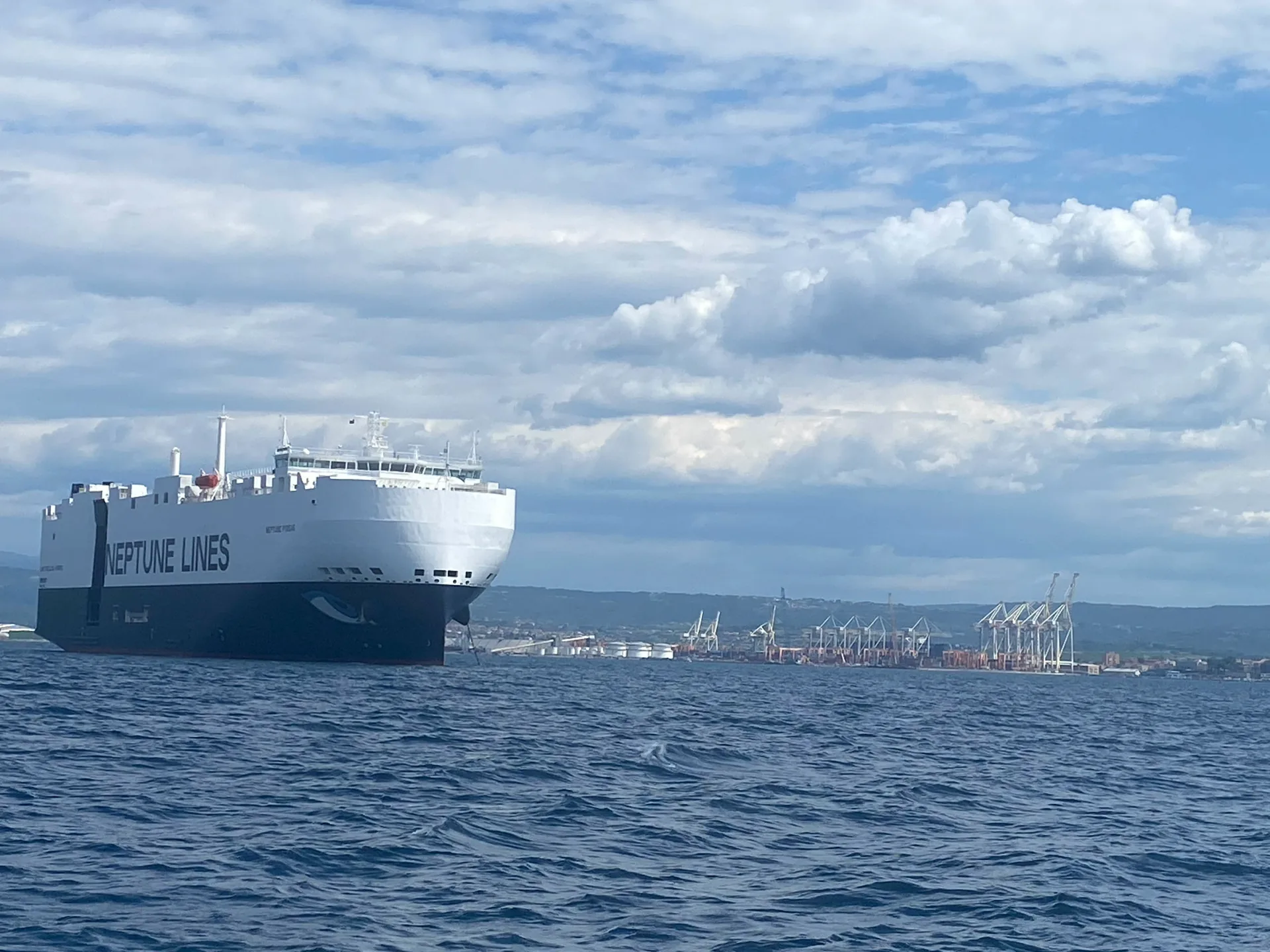 Großes Handelsschiff vor der Küste, gesehen von einer Segelyacht