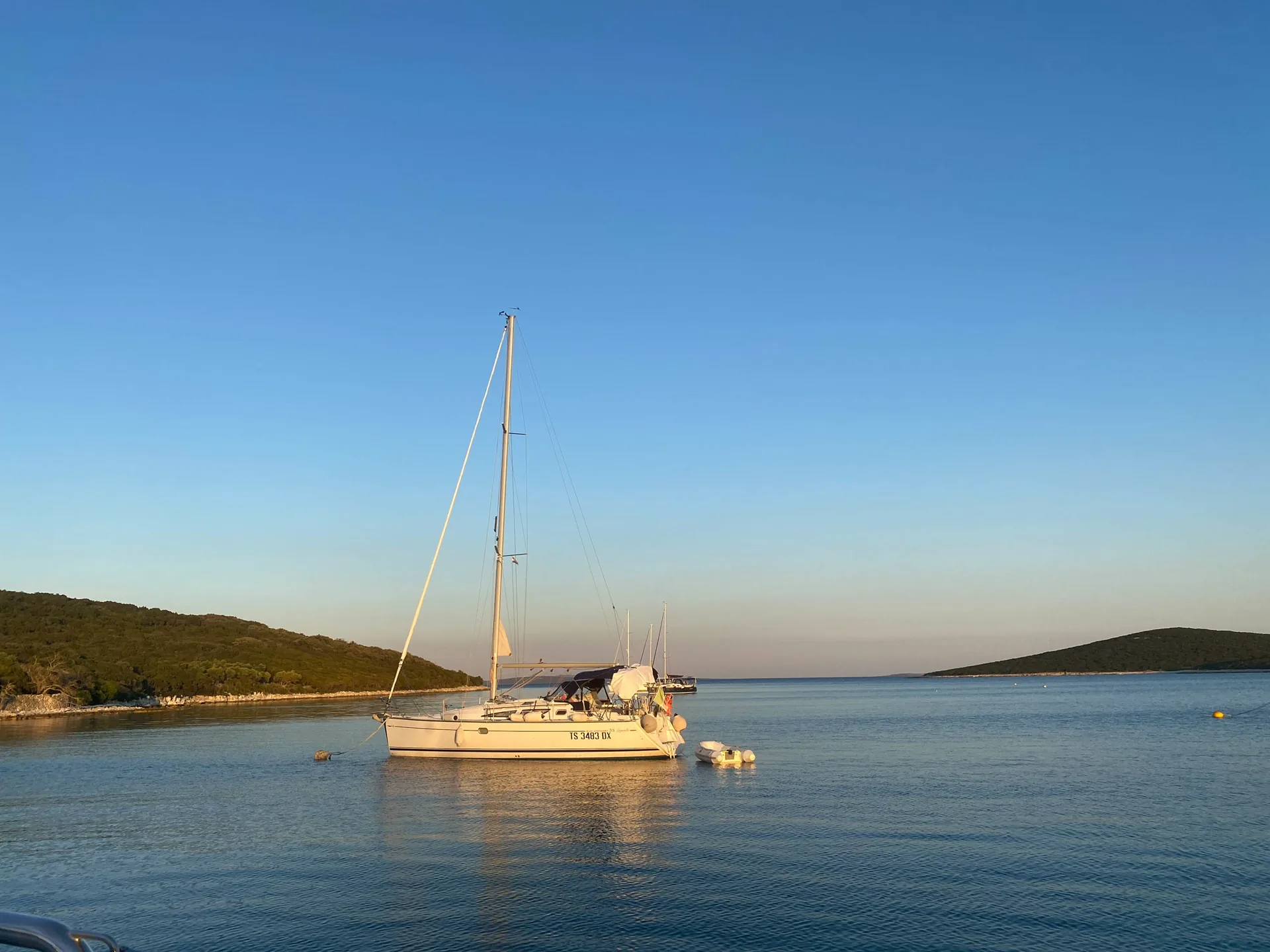 Segelyacht an einer Boje in einer geschützten Bucht vor Unije