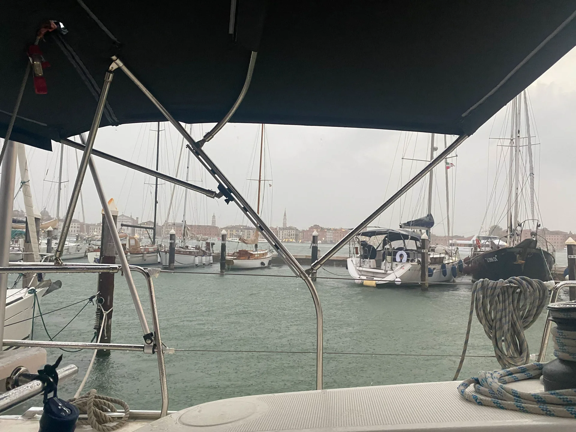 Dunkle Wolken über einer Marina, gesehen aus dem Cockpit der SY HERA