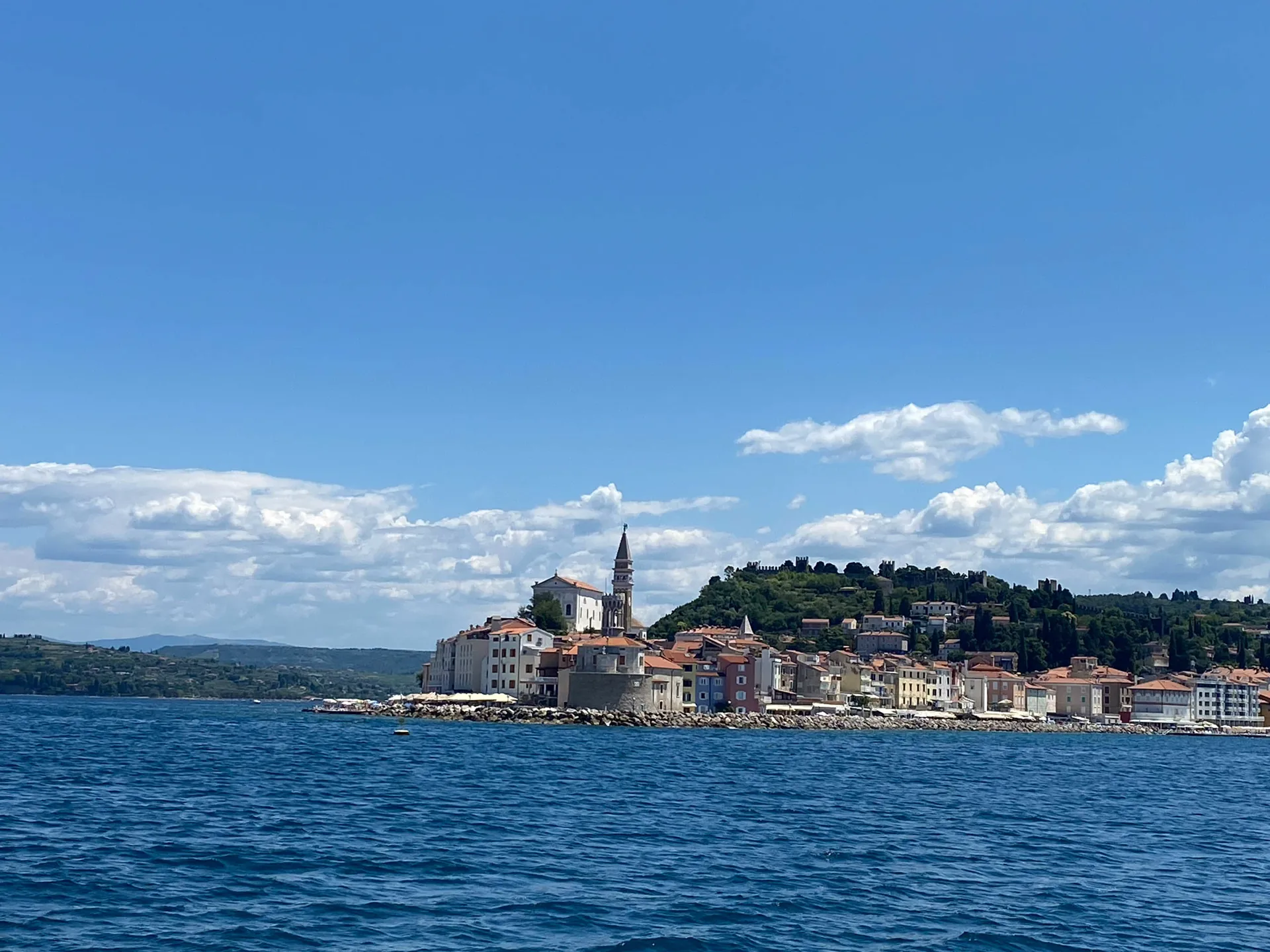 Piran mit der Kirche St. Georg und der Stadtmauer vom Wasser aus gesehen