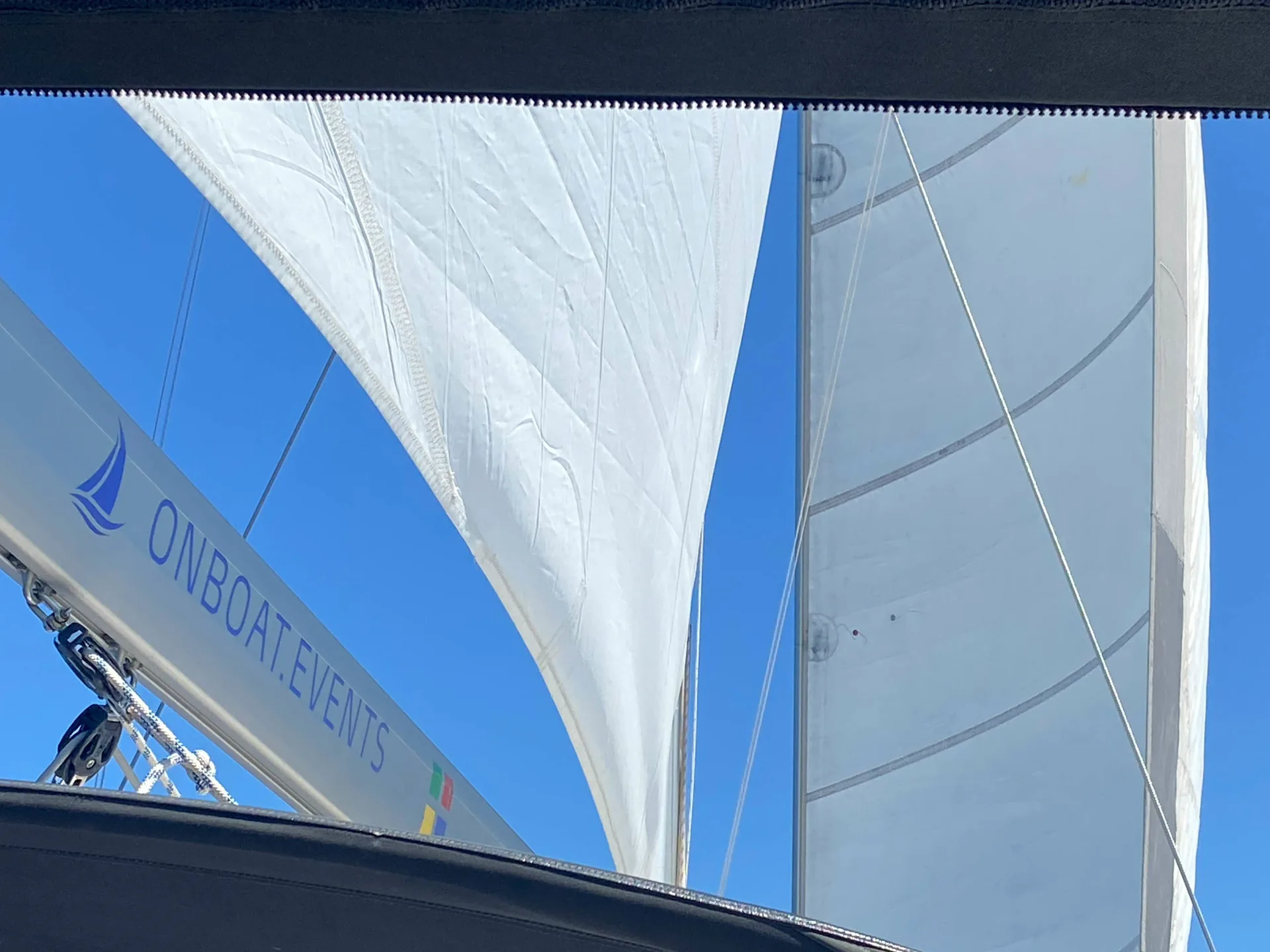 Segel der SY HERA auf offenem Wasser unter blauem Himmel