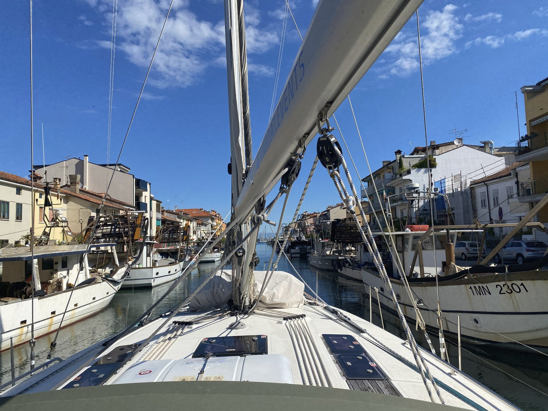 View across the foredeck of a sailing yacht in harbour – arriving, lines and life aboard